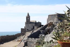 a castle on a cliff next to the ocean at Casa Manola in Le Grazie