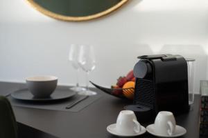 a table with a coffee maker and a bowl of fruit at MG Sapphire Junior Premium Suite in Thessaloniki