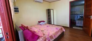 Un dormitorio con una cama rosa con un osito de peluche. en DEBIDIEN APARTMENT, en Paramaribo