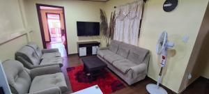 sala de estar con 2 sofás y TV de pantalla plana en DEBIDIEN APARTMENT, en Paramaribo
