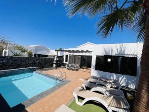 Una villa con piscina y un complejo turístico. en Casa Rosa, en Playa Blanca