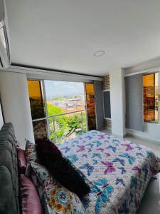 Lujoso Apartamento para Vacaciones y Negocios في كارتاغو: غرفة نوم بسرير ونافذة كبيرة