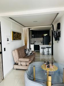 Lujoso Apartamento para Vacaciones y Negocios في كارتاغو: غرفة معيشة مع أريكة وطاولة زجاجية