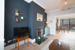una sala de estar con una pared azul con chimenea en Pass the Keys Cosy Stylish house near Southend en Southend-on-Sea