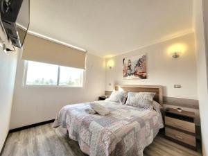 een slaapkamer met een groot bed en een raam bij Condominio Pacífico III in La Serena