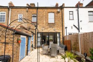 a patio in front of a brick building at Pass the Keys Cosy Stylish house near Southend in Southend-on-Sea
