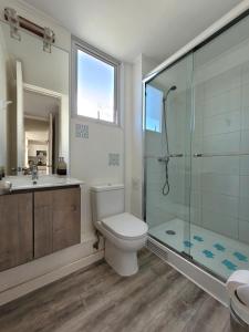 a bathroom with a toilet and a shower and a sink at Condominio Pacífico III in La Serena