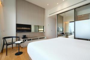 um quarto com uma cama grande, uma secretária e uma cadeira. em Hotel Kivir em Sevilha