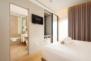 塞维利亚Hotel Kivir的一间带床和浴室的酒店房间
