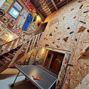 a climbing wall with a table in front of it at LE GRAND LOGIS, chambre Santorin avec spa privatif 