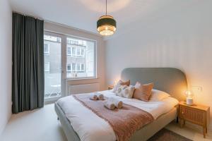 una camera da letto con un grande letto con due asciugamani di Spacious apt in the centre of Ostend near coast a Ostenda