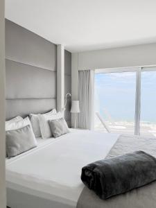 een slaapkamer met een groot wit bed en een raam bij CDesign Hotel in Rio de Janeiro