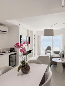 CDesign Hotel في ريو دي جانيرو: غرفة معيشة بيضاء مع طاولة وكراسي