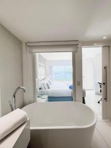 una vasca da bagno bianca in una camera con un letto di CDesign Hotel a Rio de Janeiro