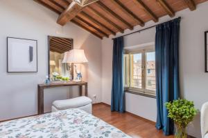 a bedroom with a bed and a window with blue curtains at De Nobili Penthouse Apartment with Elevator in Lucca in Lucca