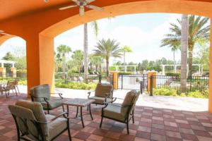 eine Gruppe von Stühlen und Tischen auf einer Terrasse in der Unterkunft 610 Bungalow at Watersong & pool in Davenport