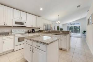 eine große weiße Küche mit weißen Schränken und Geräten in der Unterkunft 610 Bungalow at Watersong & pool in Davenport