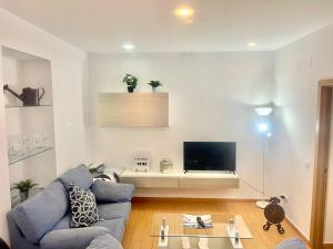 salon z niebieską kanapą i telewizorem w obiekcie CASITA ANDALUZA CENTRO con PARKING sujeto a disponibilidad w Maladze