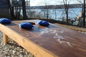 a wooden table with three blue pillows on it at Modern Getaway - New Outdoor Amenities! - Location in Osage Beach