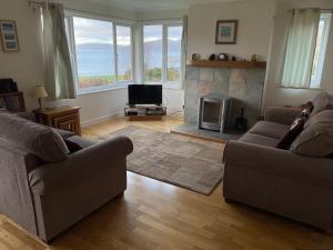 a living room with two couches and a fireplace at The Cottage, overlooking Loch Fyne in Cairndow