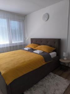sypialnia z dużym łóżkiem i żółtym kocem w obiekcie Apartman ANJA w mieście Vukovar