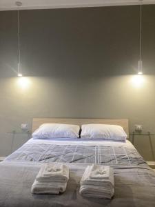 due asciugamani su un letto con due luci sopra di La Casa di EMMA a Corsico