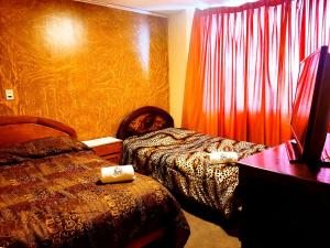 a hotel room with two beds and a red curtain at HOTEL MIRADOR DE LOS ANDES in La Paz