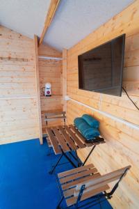 eine Sauna mit 2 Stühlen und einem Flachbild-TV in der Unterkunft ZALUAY - Habitaciones de madera in Isla Cristina