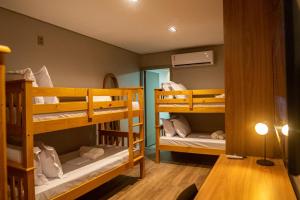 a room with three bunk beds and a table at HOTEL SERRA DA CAPIVARA RESORT E CONVENTION in São Raimundo Nonato