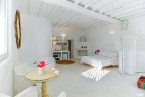 a white room with a bed and a table at Nikis Home in Mikonos