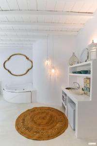 Una cocina blanca con un círculo de madera en el suelo. en Nikis Home, en Mykonos ciudad