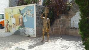 una estatua de un niño sosteniendo un cubo en su cabeza en CasaMrichica1, en Ribeira Grande