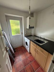 a kitchen with a sink and a washing machine at Mmc serviced accommodation 2 in Leigh