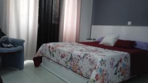 Schlafzimmer mit einem Bett mit einer roten Bettdecke in der Unterkunft CasaMrichica1 in Ribeira Grande