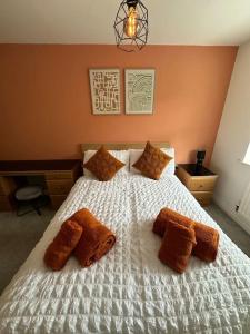 a bedroom with a white bed with brown pillows at Mmc serviced accommodation 2 in Leigh