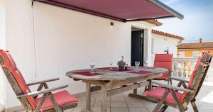 a wooden table with two wine glasses on a balcony at Villa Patricija in Medulin
