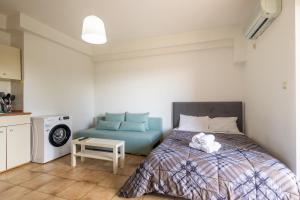 - une chambre avec un lit et un canapé bleu dans l'établissement Elia mini suites 6, à Larissa