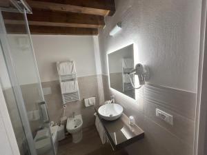 a bathroom with a sink and a toilet and a mirror at Hotel Vittoria in Rubano