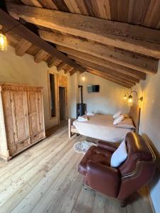 a bedroom with a bed and a couch in a room at Chalet Valchiavenna in San Cassiano