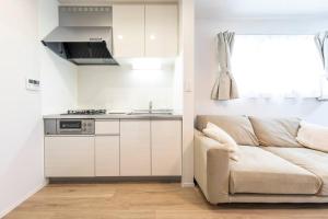 a living room with a couch and a kitchen at Logement Aile 202 in Takasaki