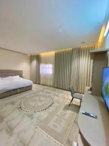 a bedroom with a bed and a desk and a television at مشار العلا AL ULA in AlUla