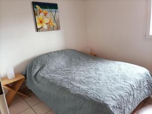 a bedroom with a bed and a painting on the wall at Fleur De Sel in Gruissan