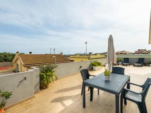 une terrasse avec une table, des chaises et un parasol dans l'établissement Casa Giovele, à Selargius