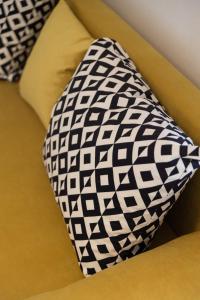 a black and white tie sitting on a yellow couch at Elia mini suites 5 in Larisa
