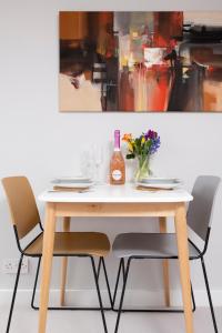 a table with chairs and a bottle of wine on it at Cosy Loft Retreat, King Bed, En-suite, Kitchenette, Homestay in Brighton & Hove
