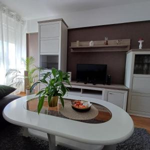 a living room with a white table and a tv at Apartman West Side in Zaprešić