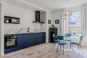 cocina con armarios azules, mesa y sillas en Casa Drago, en Bolonia