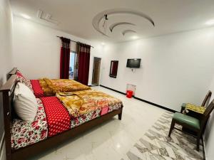 - une chambre avec un lit et une chaise dans l'établissement Zaib guest house for families in E-11 Islamabad, à Islamabad