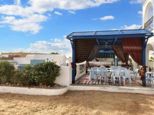 a group of white chairs on a patio at 5 bedrooms villa with private pool enclosed garden and wifi at Djerba 1 km away from the beach in Houmt Souk