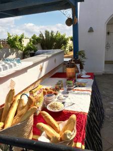 a table with bread and other food on it at 5 bedrooms villa with private pool enclosed garden and wifi at Djerba 1 km away from the beach in Houmt Souk